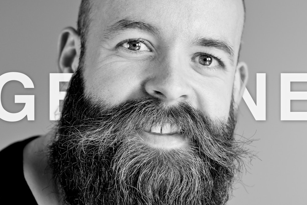 Bearded man with GENUINE text behind the subject